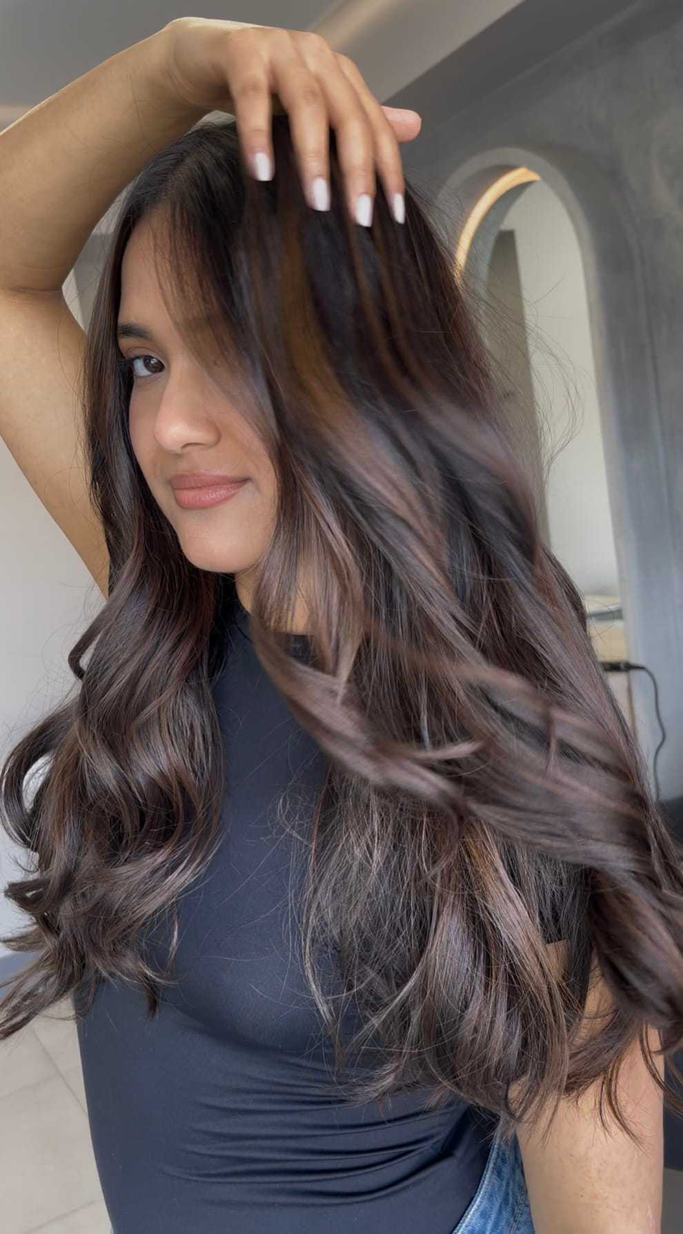 Long, wavy brown hair flowing naturally around a woman's smiling face.